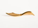 gold plated spoon with a curved handle on a white background