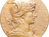 un gros plan sur une médaille d'or représentant la tête d'une femme