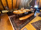 a room with a table, chairs, rugs and a couch in it
