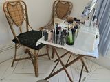 une table avec un miroir et une chaise dans un coin de la pièce