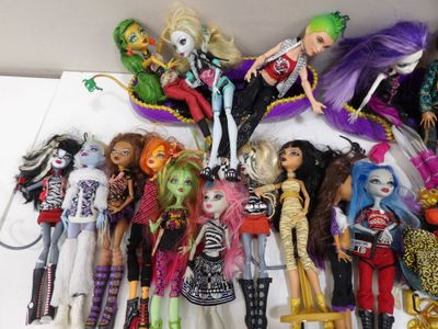 il y a plein de poupées Monster High sur la table