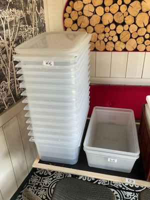 une pile de récipients en plastique posée à côté d'un tas de bois