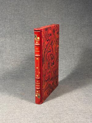 a red book sitting on top of a table next to a gray wall