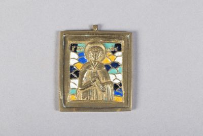 une image représentant un pendentif en or sur lequel figure une femme tenant un enfant dans ses bras