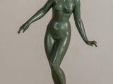 statue of a woman standing on a black base on a table