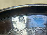a close up of a silver plate with a design on it