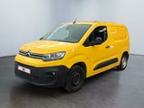 une camionnette jaune garée dans une pièce au sol noir