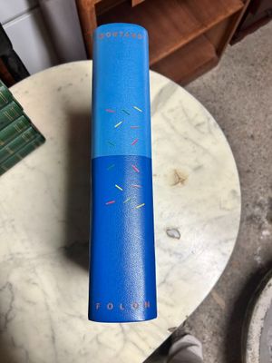 the blue book is sitting on a table next to a pair of shoes