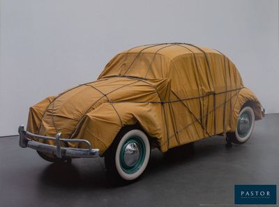 a car covered with a tarp sitting on the floor