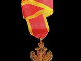 an image of a gold medal with a red and yellow ribbon
