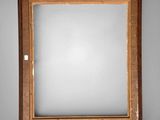 an old wooden frame with a mirror hanging on the wall