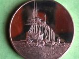 a silver coin with a picture of a ship on it