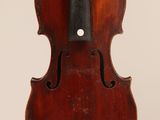 an old violin hanging from the back of a white wall