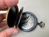 a person that is holding a pocket watch in their hand