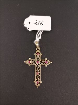 a cross with a tag attached to it on a black surface