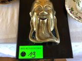 une statue en or représentant un homme barbu, posée sur une table