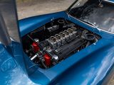 a close up of a blue car with a engine in it ' s trunk