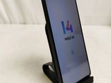 a close up of a cell phone on a stand on a bed