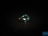 gros plan d'un diamant vert sur une surface noire