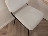 une chaise blanche posée dans un coin d'une pièce
