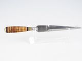 couteau à manche en bois posé sur un socle transparent, sur une surface blanche