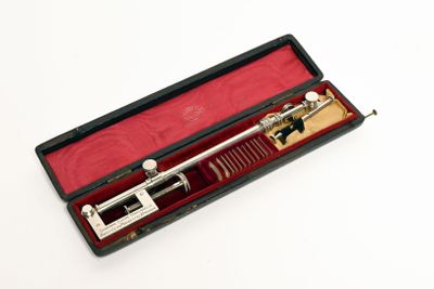 un instrument argenté et noir dans un étui rouge