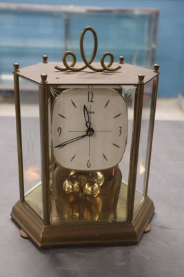 une horloge en or posée sur une vitrine