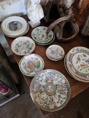 de nombreuses assiettes et bols posés sur une table, avec une statue en arrière-plan