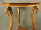 une table en bois avec un plateau incurvé sur lequel sont posés deux oiseaux