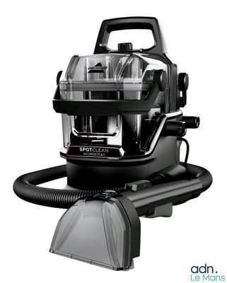 the black and white photo shows a vacuum cleaner and a duster