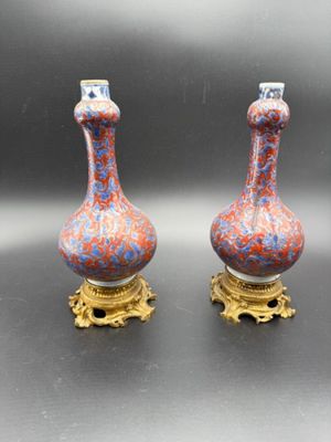 pair of vases sitting on top of a table next to each other