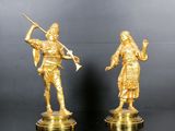 pair of antique brass figurines of a man and a woman holding a sword