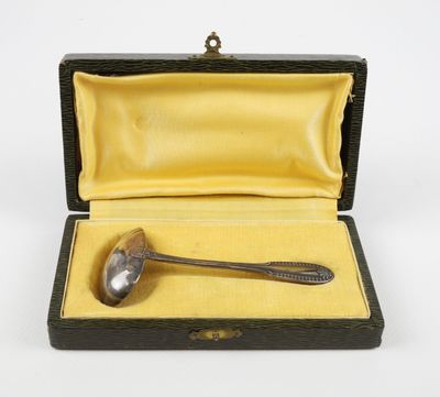 une cuillère ancienne en argent dans un étui noir doublé de jaune