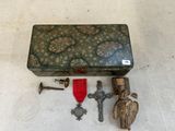 une boîte contenant une croix, une médaille et d'autres objets, posée sur une table