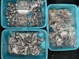 three blue plastic containers filled with assorted metal items on top of a black surface