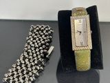 two watches and a bracelet on a black table
