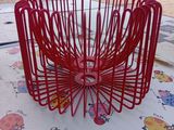 un panier en fil de fer rouge posé sur une table
