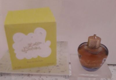 un petit flacon de parfum posé à côté d'une boîte