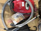 un aspirateur rouge posé sur une boîte