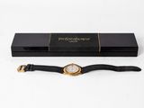 a black and gold watch with a black strap in a black box