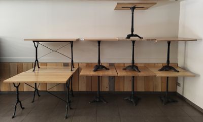 three tables and two benches in the corner of a room