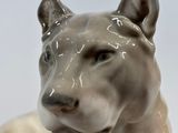 a ceramic statue of a lion laying down on the ground