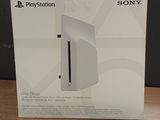 La boîte de la console PlayStation est posée sur la table.