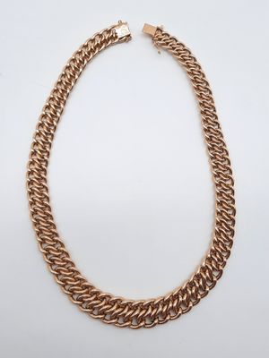 une image représentant un collier à chaîne en or sur fond blanc