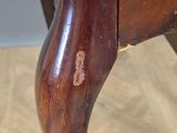 a close up of a wooden chair with a curved arm