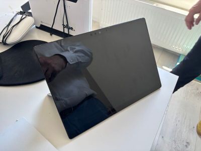 a laptop computer sitting on a table next to a pair of shoes