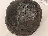 an image of a black ball of dough on a white surface