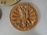 a gold coin with a bird on it next to a coin with a bird on it