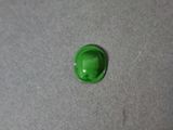 a close up of a green button on a gray surface
