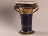 un vase bleu orné d'une décoration dorée